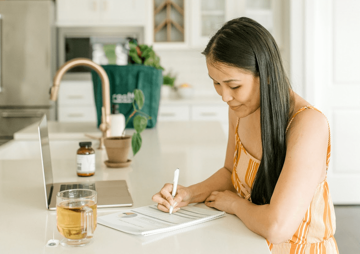 woman with laptop taking notes